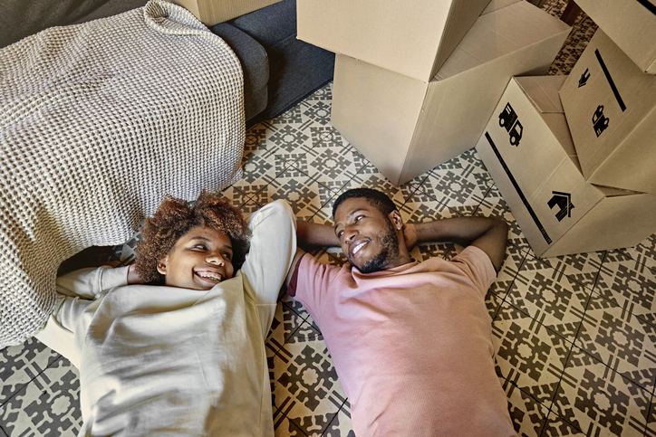 Afro-Caribbean Couple Relaxing Side by Side on Moving Day